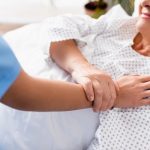 senior woman in hospital bed with caring nurse